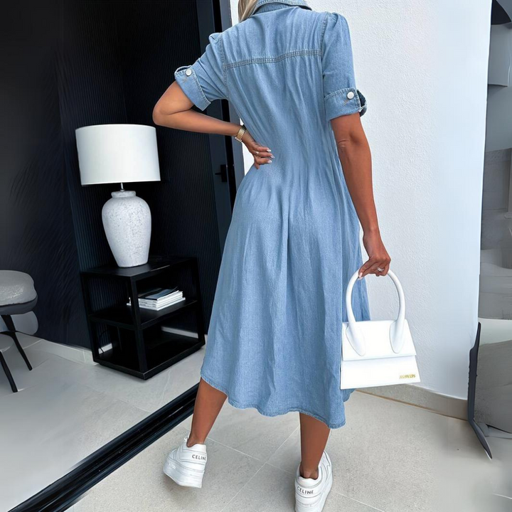 Sukienka jeansowa midi koszulowa w casualowym stylu, modelka w białych trampkach i z torebką