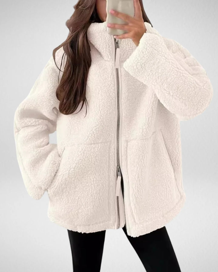 Kobieta w białej kurtce damskiej polarowej teddy oversize z zamkiem błyskawicznym i kieszeniami bocznymi