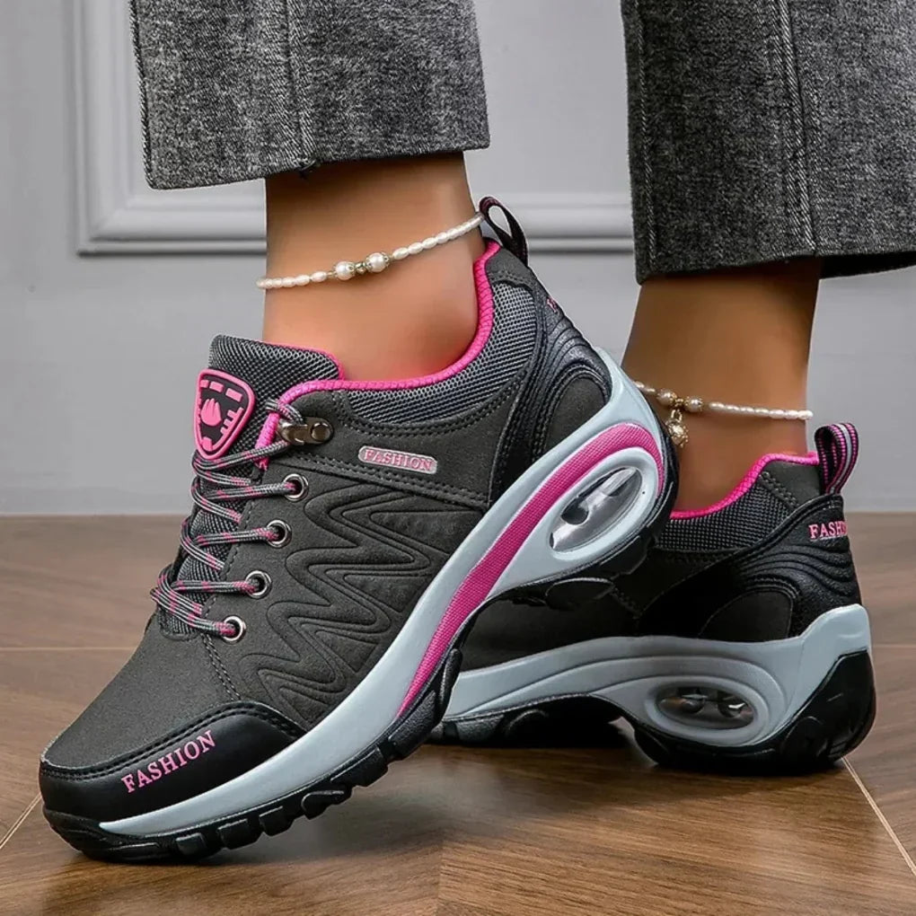 Damskie wodoodporne buty trekkingowe z różowymi akcentami i antypoślizgową podeszwą na stopach modelki