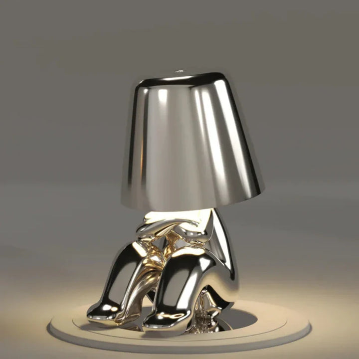 Zestaw designerskich lamp LED z połyskującym wykończeniem i kloszami na komodzie