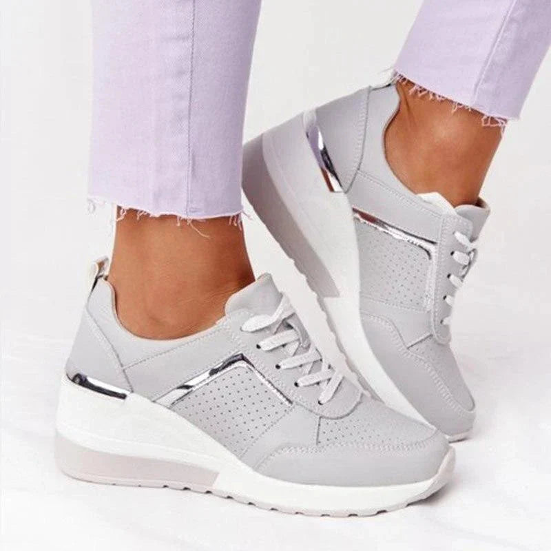 Białe sneakersy damskie ortopedyczne na koturnie z boku, widoczne sznurowanie i metalowe detale na pięcie