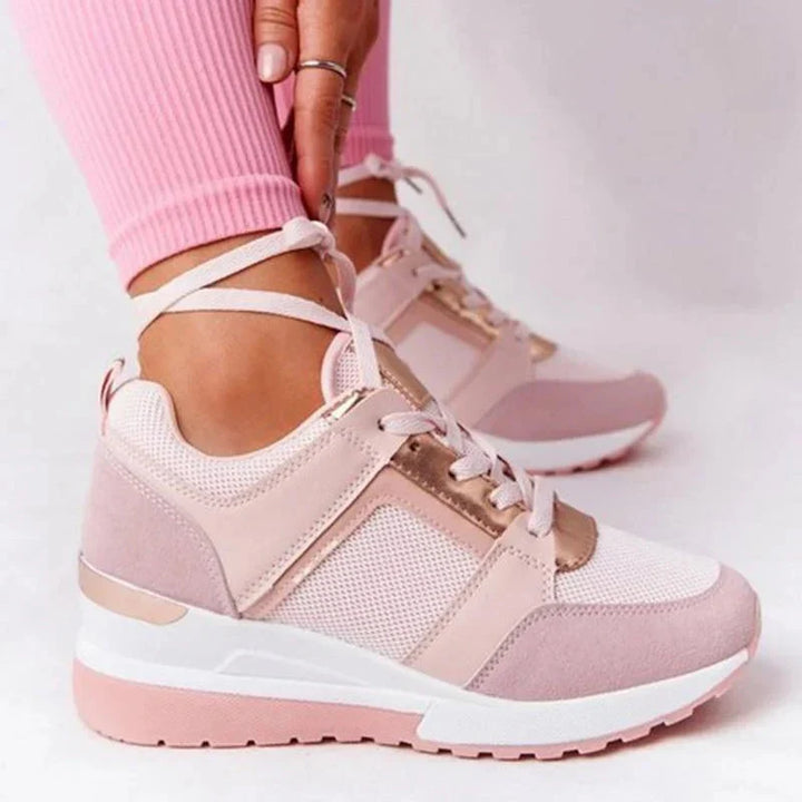 Białe sneakersy damskie na koturnie z perforacją, widok z boku pokazujący podwyższoną podeszwę i stabilną konstrukcję