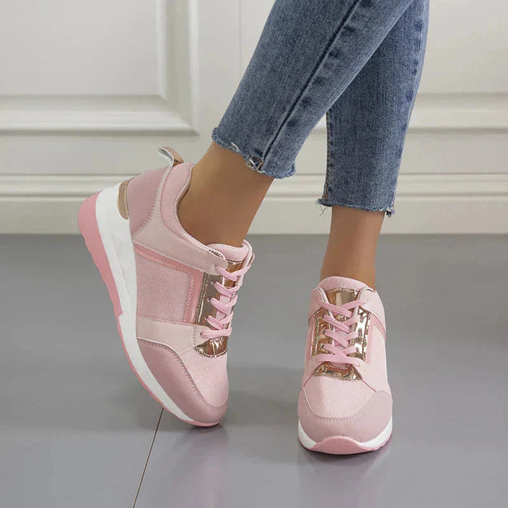 Białe sneakersy damskie na koturnie z tyłu, widoczne metalowe detale i stabilna podeszwa