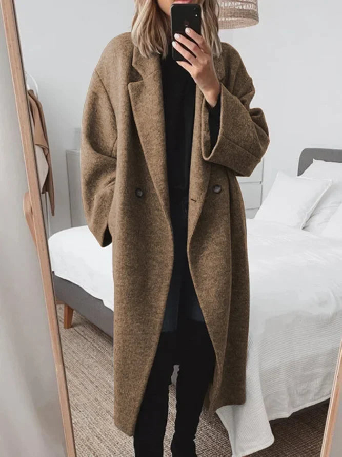 Woman in grey oversized coat with double-breasted closure and structured wool-blend fabric