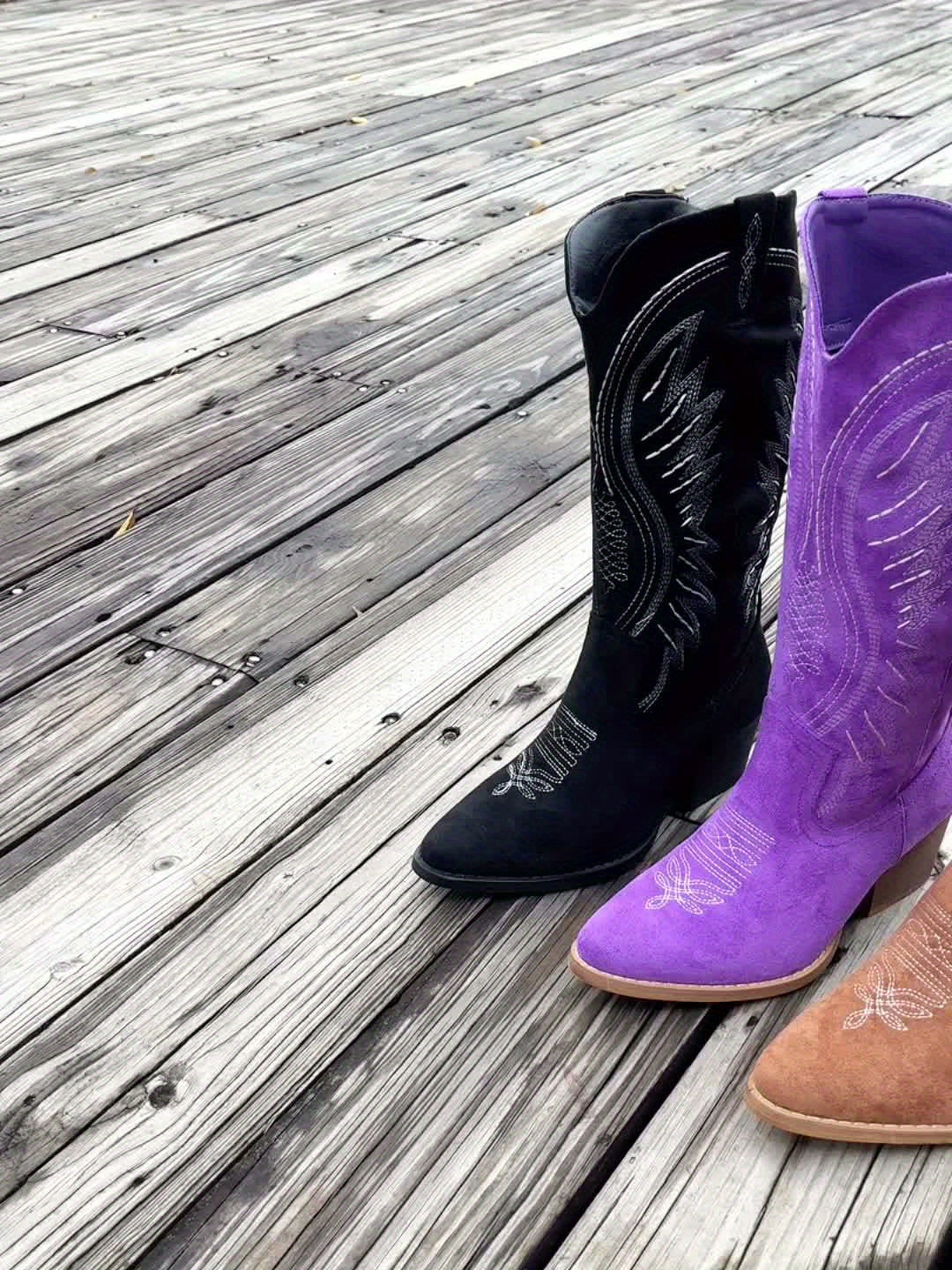 Women's tan cowboy boots on outdoor surface highlighting full boot height and block heel