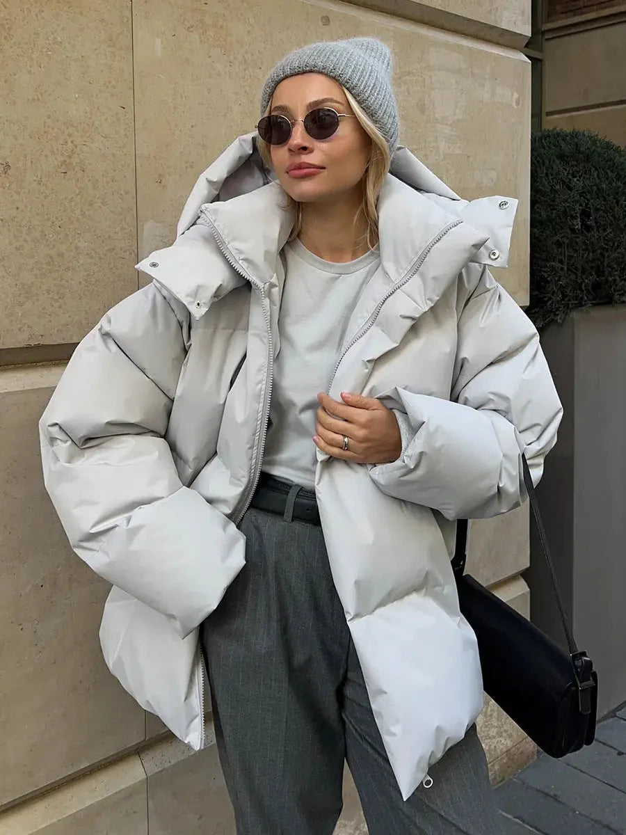 Kurtka puchowa damska oversized czarna, widok z boku prezentujący luźny krój