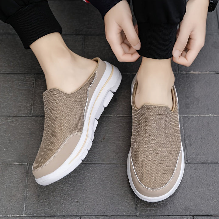 Czarne klapki męskie slip-on na białym tle z wyraźnym bieżnikiem podeszwy