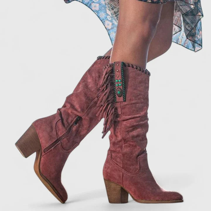 Women's fringe cowboy boots in burgundy with embroidered trim and block heel worn with patterned dress