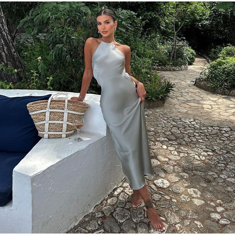 Kobieta w maxi sukience kopertowej z odkrytymi plecami, zwiewna tkanina o gładkim wykończeniu, elegancki krój