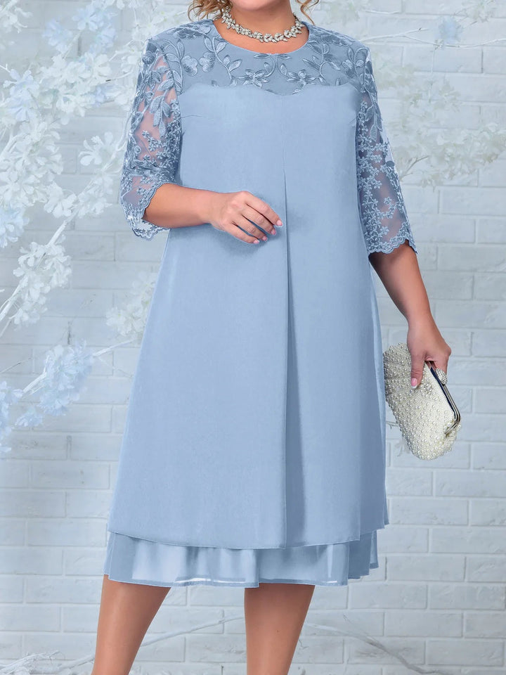 Detal haftu kwiatowego na przezroczystych rękawach sukienki plus size w fasonie trapezowym