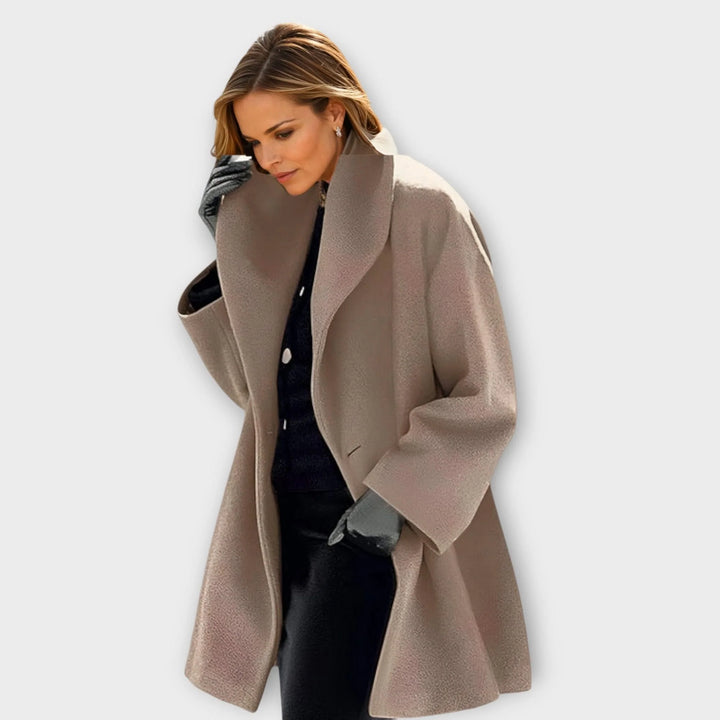 Płaszcz damski wełniany oversized w jasnym kolorze, prezentowany z czarnymi rękawiczkami i elegancką stylizacją