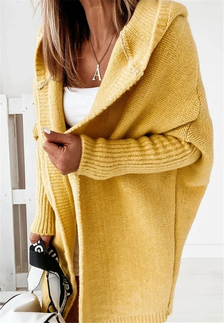 Sweter damski rozpinany oversize noszony z białą bluzką i jasnymi spodniami