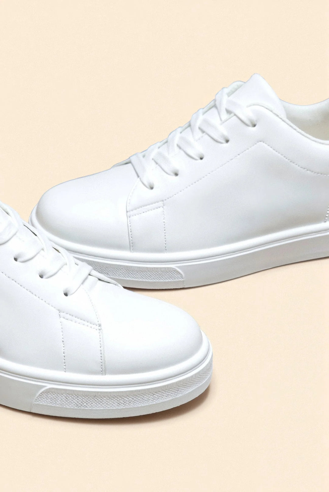 Sneakersy męskie białe z bliska ukazujące detale sznurowania i gładką fakturę materiału