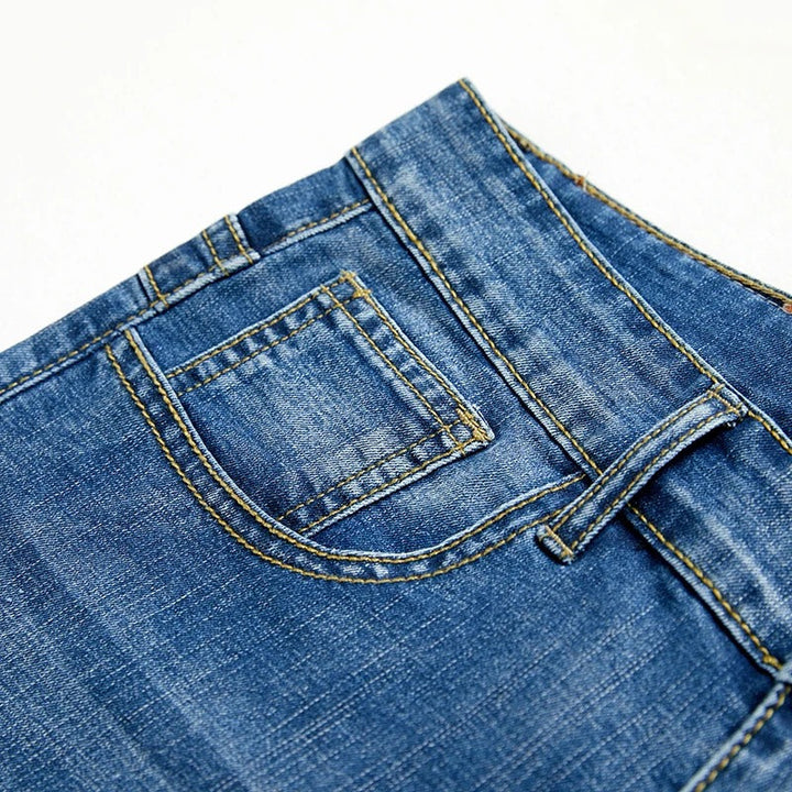 Detale tylnych kieszeni spodenek jeansowych męskich z kontrastowym przeszyciem i patch skórzany