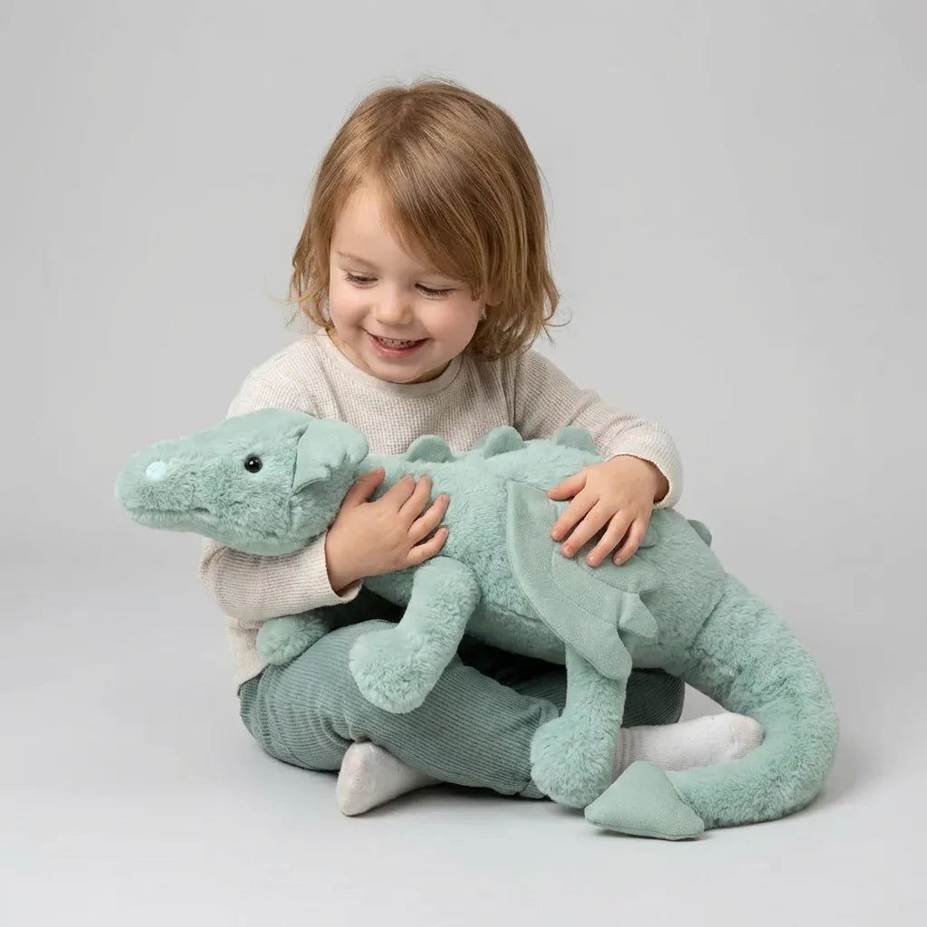 Pluszowa zabawka CuddleDragon – miękki smok w kolorze miętowym trzymany przez dziecko, widoczne detale pyska i skrzydła