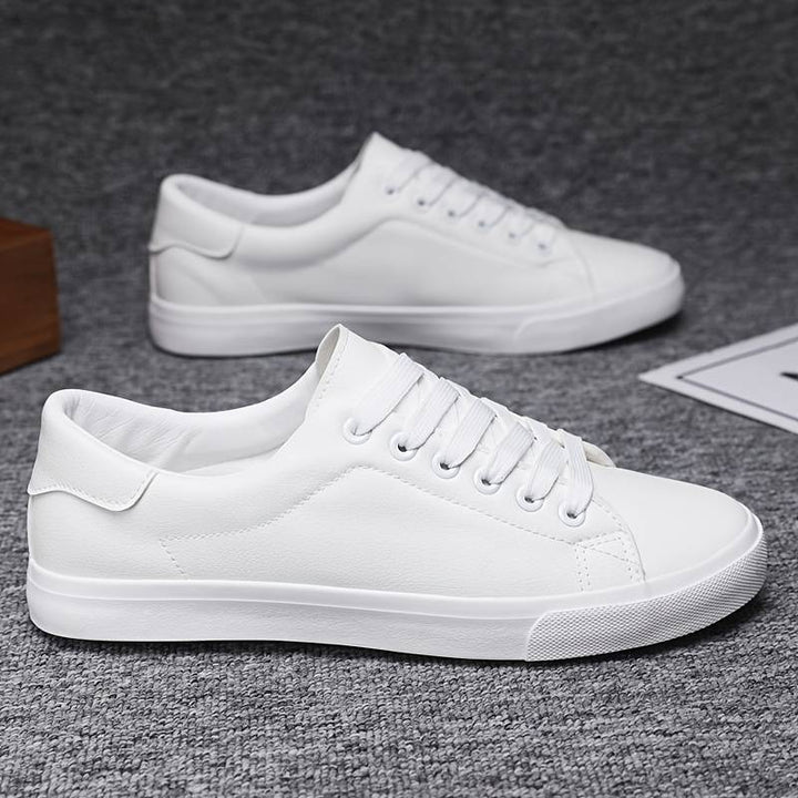 Klasyczne białe sneakersy z czarnym detalem, sznurowanie, teksturowana podeszwa, minimalistyczny styl, widok z przodu.