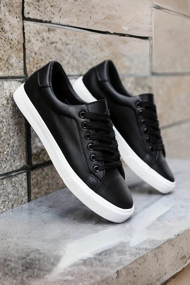 Sneakersy męskie białe z kontrastowym panelem, niskie wykończenie, gładki materiał, zaokrąglony czubek, widok z boku.