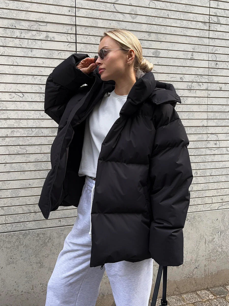 Kobieta w jasnej kurtce puffer oversize z obszernym kapturem i funkcjonalnymi kieszeniami