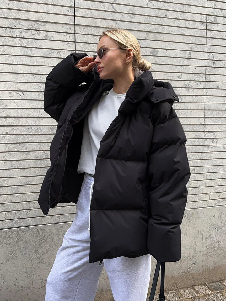 Kobieta w jasnej kurtce puffer oversize z obszernym kapturem i funkcjonalnymi kieszeniami