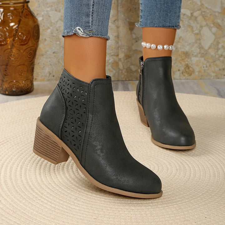 Women's ankle boots styled with casual denim, showing block heel and laser-cut sides