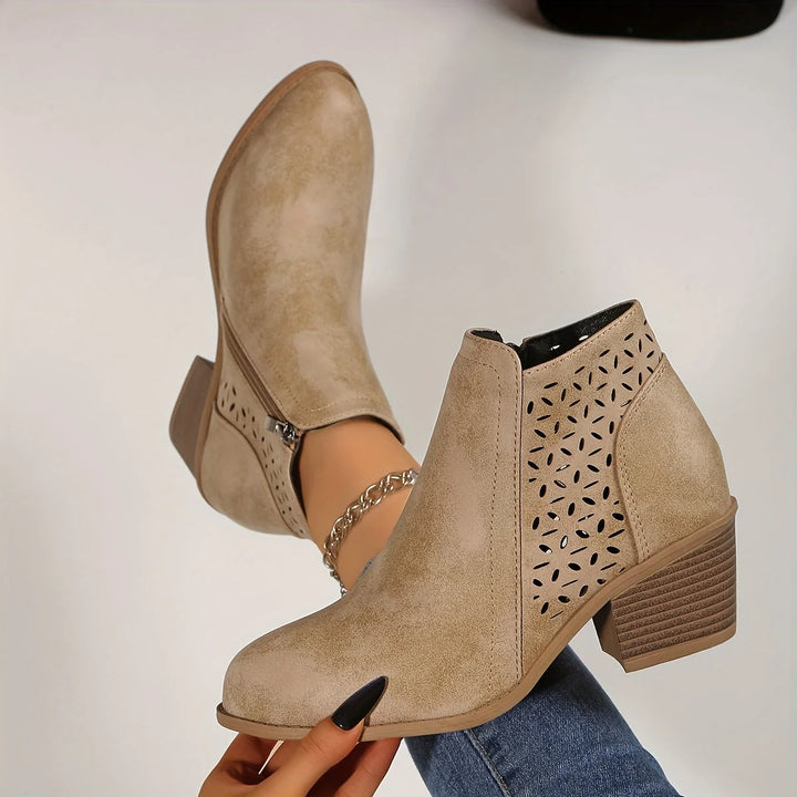 Detail shot of stacked block heel and laser-cut geometric pattern on women's ankle boots