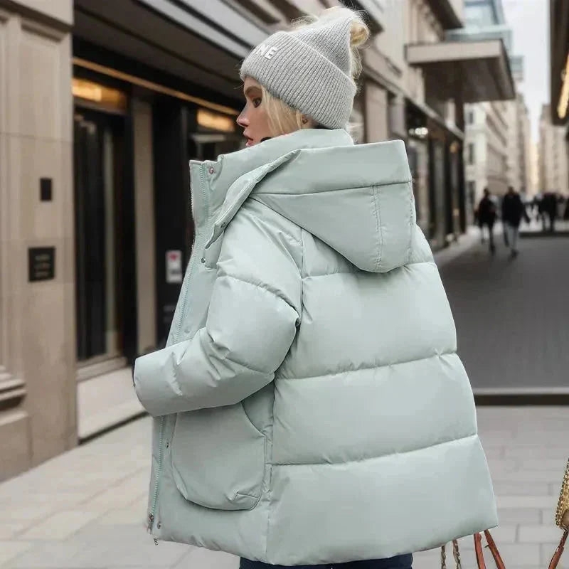 Kobieta nosząca czarną kurtkę pikowaną oversize z wysokim kołnierzem, stylizacja miejska