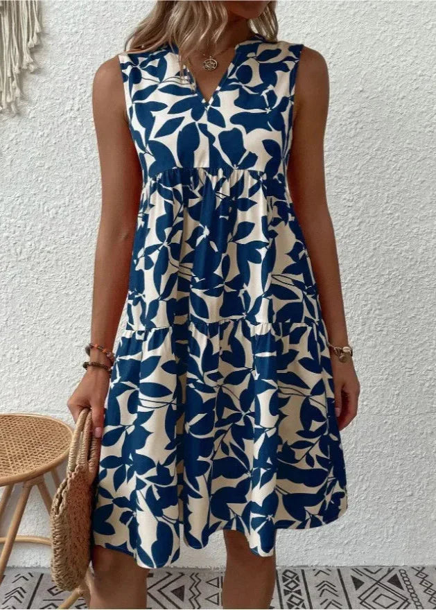 Kobieta w eleganckiej sukience letniej midi z wzorzystym printem i zwiewnym krojem idealnym na ciepłe dni