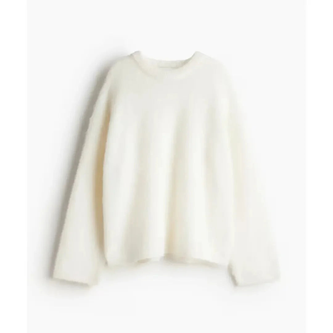 Sweter damski oversize w kremowym kolorze z okrągłym dekoltem i długimi rękawami na białym tle