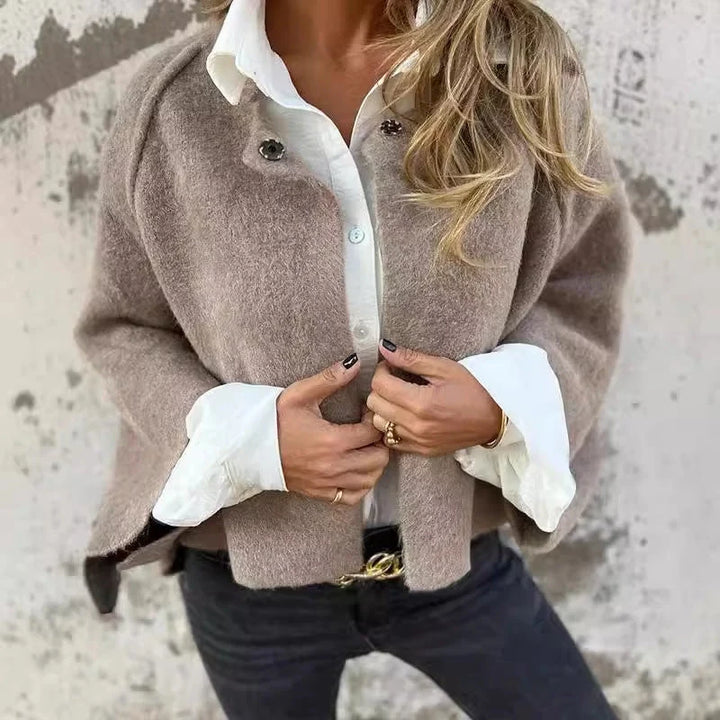 Miękka i elegancka krótka kurtka damska w kolorze beżowym z kontrastowymi białymi detalami przy kołnierzyku i mankietach