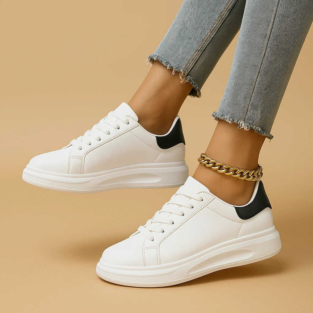Sneakersy damskie w białym kolorze z minimalistycznym wykończeniem i niską cholewką w miejskim otoczeniu