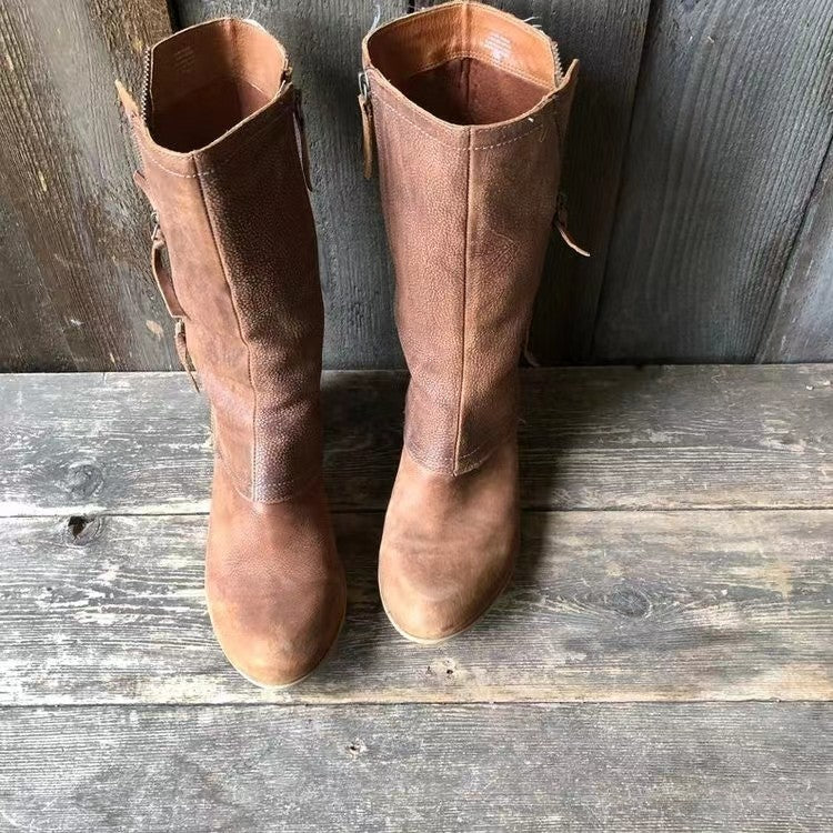 Close-up view of women's mid-calf boots showing side zip fastening and tassel pull detail